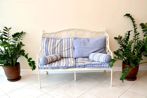 Metalowa sofa z dekoracyjnymi poduszkami i roślinami. Fragment wnętrza hali — Zdjęcie stockowe
