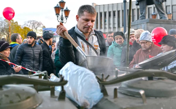 Kaliningrad, Rusland - 07 november 2017: Een man deelt gratis warm eten uit aan deelnemers aan een communistische rally — Stockfoto