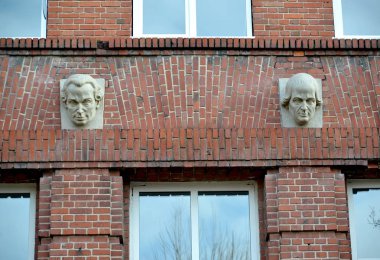 Kaliningrad, Rusya - 14 Ocak 2020: Spor salonunun tuğla cephesinde Immanuel Kant ve Johann Gerder 'in heykel portreleri. 1