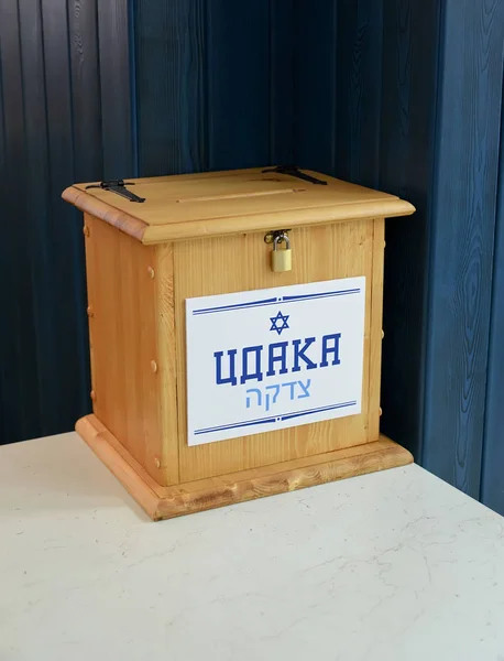 A wooden box reading "Cdaka" to collect donations at the synagogue. Russian and Hebrew text - Tsdaka — Stock Photo, Image