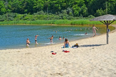 Kaliningrad Bölgesi, Rusya - 10 Haziran 2014: Çocuklar kumlu bir plajda güneşleniyor ve yıkanıyor