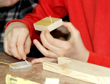 Çocuk boşluğa yapıştırıcı sürüyor. Ahşap gemi üretiminde usta çocuklar sınıfı.