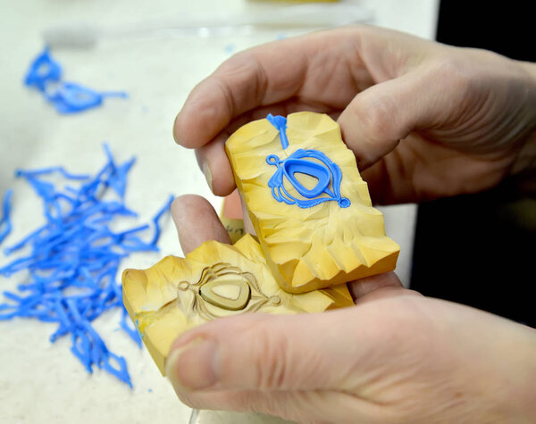 Резиновая плесень с кулонной моделью в руках ювелира
