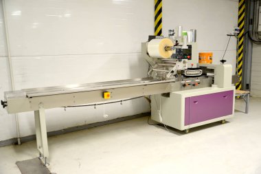 Şekerleme ambalajı için yatay ambalaj makinesi. Çikolata fabrikasında paketleme alanı