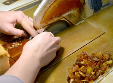 İşçi kehribar taşlarını disk testeresiyle keser. Amber İşlem Atölyesi