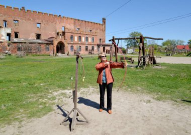 Bir kadın Shaaken Kalesi 'nde okçuluk yapıyor. Kalininingrad bölgesi