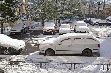 KALININGRAD, Rusya - 31 Mart 2020 Beklenmedik ilkbahar karı. Şehir bahçesi arabalar tarafından zorlanıyor.