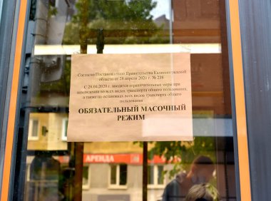 Otobüs kapısında zorunlu maske rejiminin nakledildiği duyurusu. Koronavirüs salgını Rusya 'da COVID-19. Rusça metin