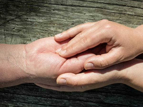 Jonge vrouw met de hand van een senior dame — Stockfoto