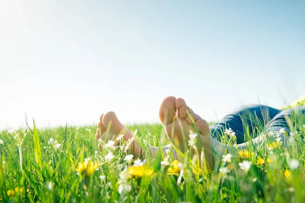 Bare feet on spring grass and flowers — Stock Photo, Image