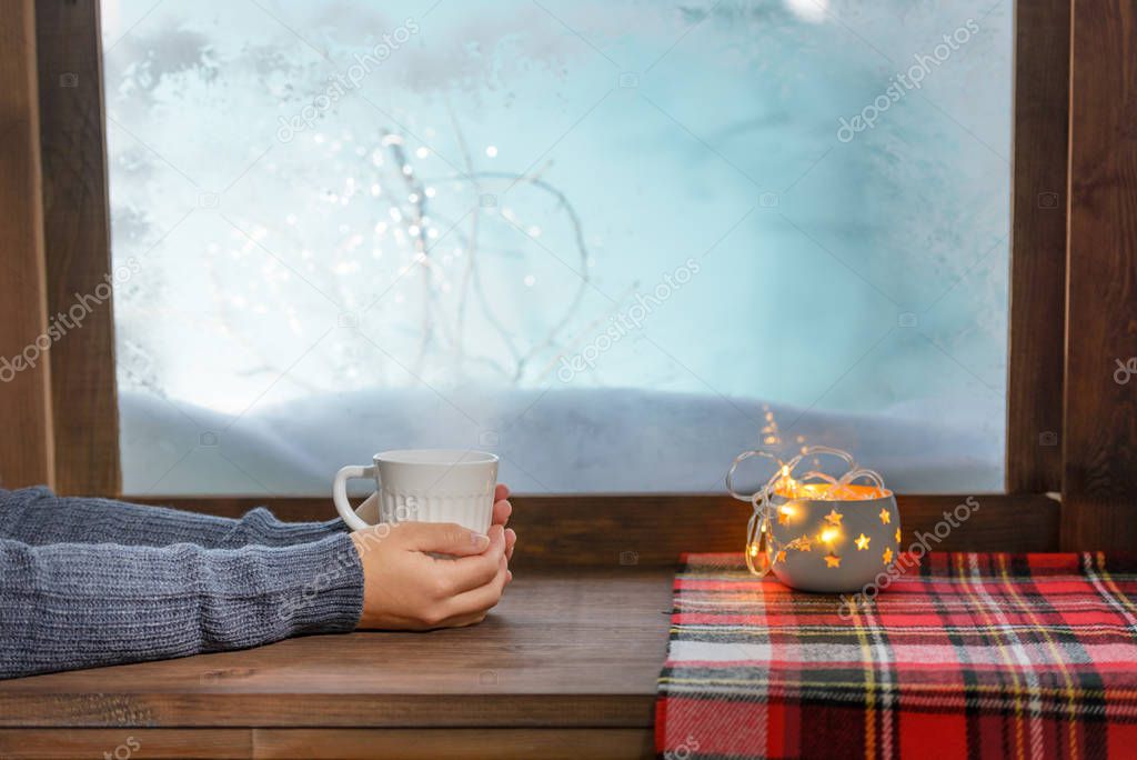 cozy winter window sill with cup of tea and warm blanket