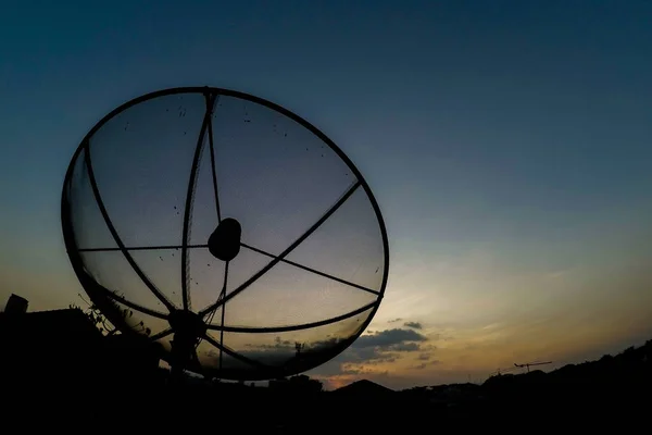 太阳在抛物卫星接收器盘之后在黄昏时间 — 图库照片