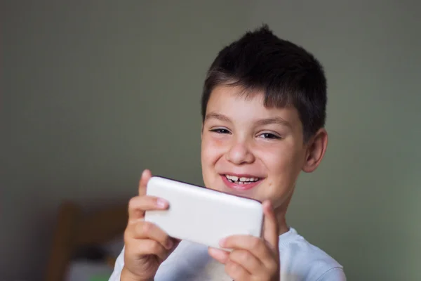 Ragazzo utilizzando uno smartphone mobile e sorridente — Foto Stock