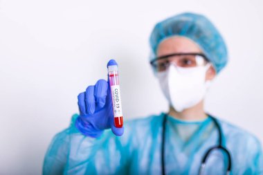 Coronavirus covid 19 elinde cerrahi maskeli ve parlayan bir kadın doktorun enfekte olmuş kan tüpü. Coronavirus covid 19 tedavi laboratuvarı, koronavirüs covid-19 aşı araştırması..