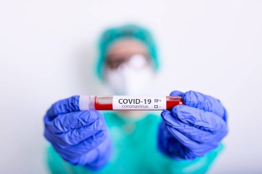 Coronavirus covid 19 elinde cerrahi maskeli ve parlayan bir kadın doktorun enfekte olmuş kan tüpü. Coronavirus covid 19 tedavi laboratuvarı, koronavirüs covid-19 aşı araştırması..