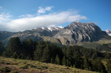Mavi, bulutlu gökyüzü ve dağlar