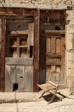 Eski bir kapı önünde eski bir sandalye