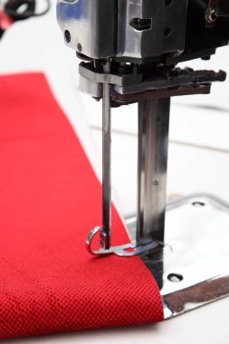 Tekstil fabrikasında dikiş makinesi ve kumaş.