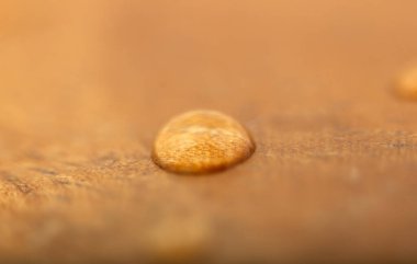 Tahta bir yüzeye bir su damlası. Desenli, Arkaplan.