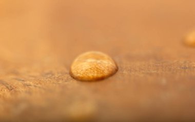 Tahta bir yüzeye bir su damlası. Desenli, Arkaplan.