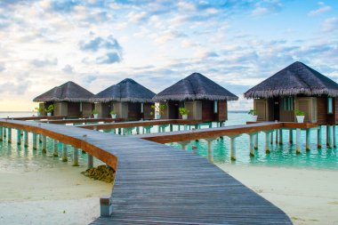 Dhidhoofinolhu, Maldivler - 5 Temmuz 2017: kumlu sahilde günbatımı manzara. Su lüks resort Hint Okyanusu, Maldivler, 5 Temmuz 2017 üzerinde ahşap bungalov