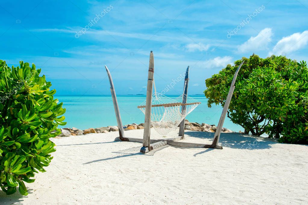 Beautiful landscape with hammock on the sandy beach, Maldives island 