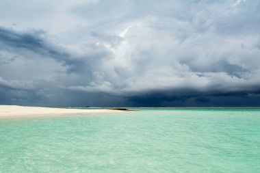 Hint Okyanusu'nun kumlu plaj fırtına öncesi sessizlik bulutlu peyzaj