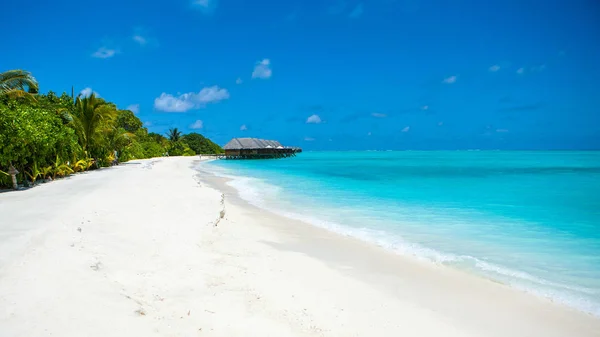 Vackra sandstrand och över vatten tropiska bungalo — Stockfoto