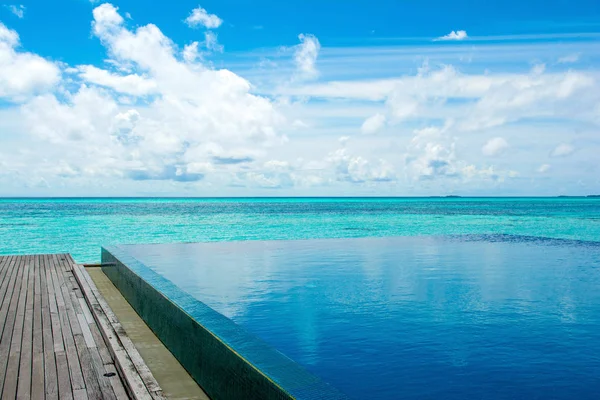 Grande piscine à débordement sur les rives de l'océan Indien avec soleils — Photo