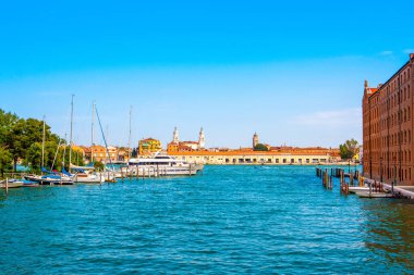 Venedik, İtalya - 2 Mayıs 2019: Venedik kanallarından birinde arka planda tekneler, yatlar, yolcu gemileri ve geleneksel renkli binalar