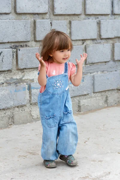 Niedliches kleines Mädchen mit nach oben gerichteten Händen — Stockfoto