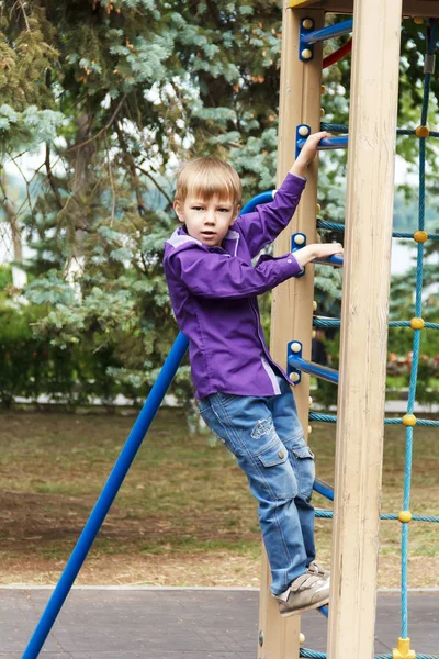 Leuke jongen beklimmen van een ladder met touw — Stockfoto
