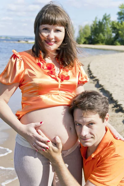 Mann umarmt schwangere Frau in Sommerdeich — Stockfoto
