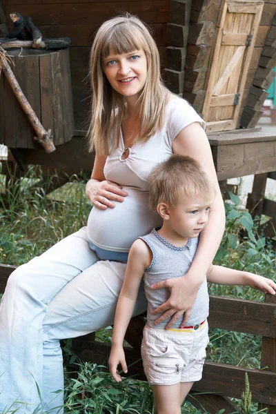 Gravid kvinna med son i sommardag — Stockfoto