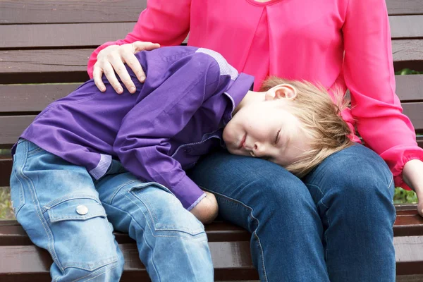 Mutter mit schlafendem Sohn macht Rast — Stockfoto