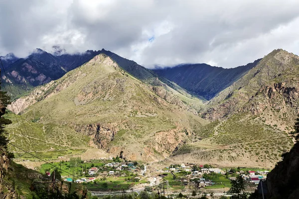 Landskap med en liten by vid foten av bergen — Stockfoto
