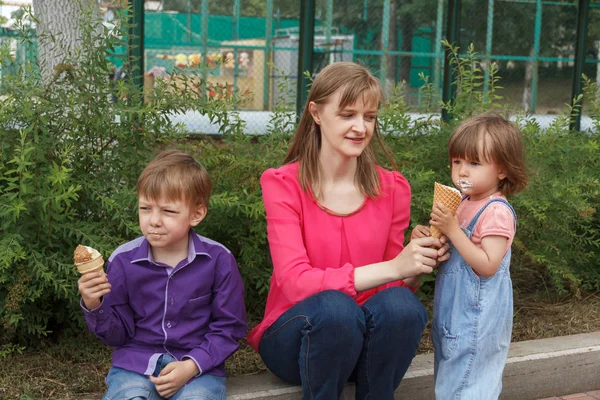 Familie sitzt im Sommerpark und isst Eis — Stockfoto