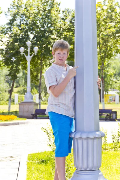 Мальчик смотрит на белую колонну — стоковое фото