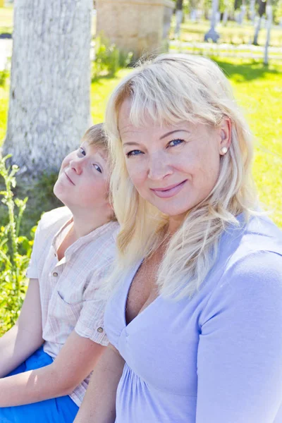 Blond kvinne og sønn som smiler om sommeren – stockfoto