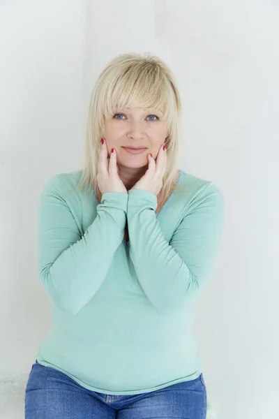 Blond woman with blue eyes in green — Stock Photo, Image