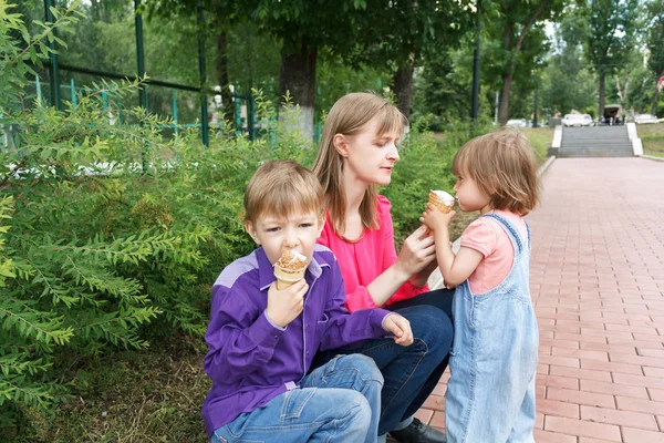 Familie sitzt im Sommerpark und isst Eis — Stockfoto