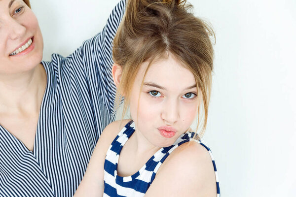 Mother and daughter playing with blond long hair