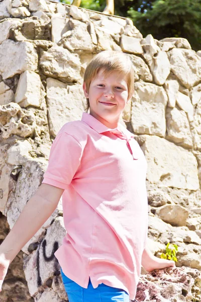 Улыбающийся мальчик в каменном парке — стоковое фото