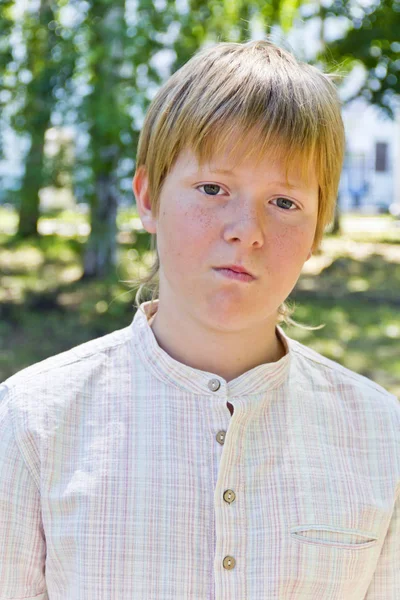 Portret van serieuze jongen in park — Stockfoto