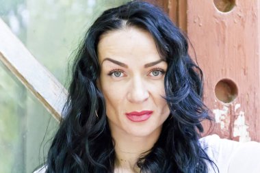 Esmer, uzun saçlı.