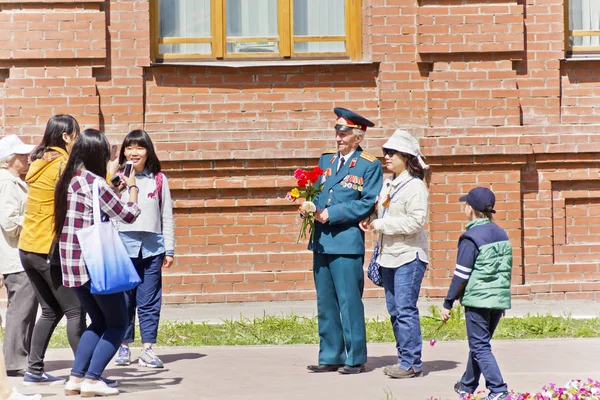 Russian veteran take a photo with foreign tourists on celebratio — Stock Photo, Image