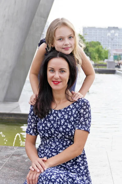 Embracing mor och dotter nära fountain — Stockfoto