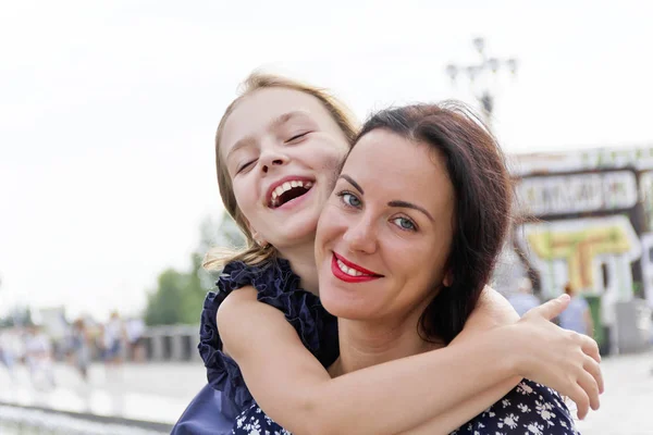 Embracing och skratta mor och dotter — Stockfoto