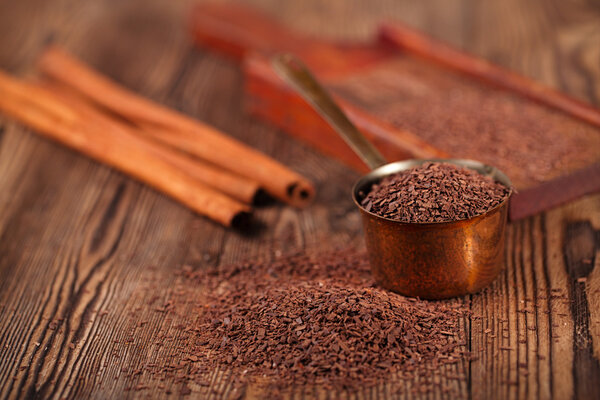 grated dark chocolate in copper measure pan 