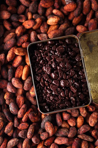 Gotas de chocolate y granos de cacao en caja — Foto de Stock